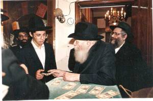 על השינוי שהתחולל אצל מייסד חב"ד סמך הרבי האחרון עת נתן עצות גשמיות לחסידיו. הרבי מליובאוויטש בחלוקת הדולרים צילום: WLCC