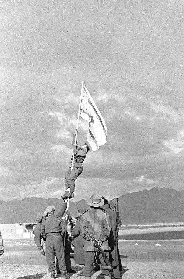 כל זמן שלא נעקר ממקומו, היה תהיה לו תקומה. הנפת דגל הדיו באילת, 1949צילום: מיכה פרי