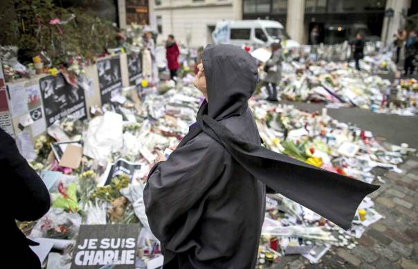 ביקורת עצמית לוקה בחסר. אישה מוסלמית באתר ההנצחה ליד משרדי שרלי הבדו בפריז צילום: אי.פי.אי  