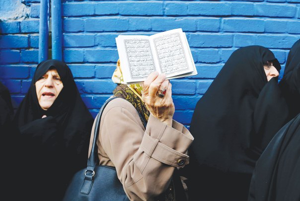 "לאיסלאם יש סיכוי גדול יותר לעבור רפורמה מאשר ליהדות האורתודוקסית" מפגינה שבידה ספר הקוראן, איראן 2015 צילום: אי.פי.אי